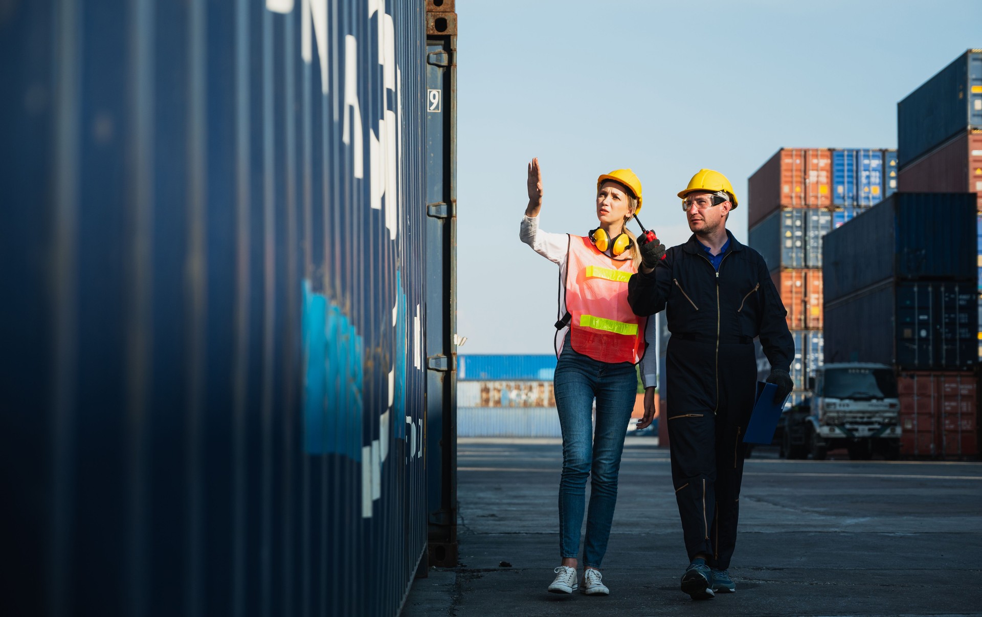 Two foreman man & woman worker working checking at Container cargo harbor to loading containers. Dock male and female staff business Logistics import export shipping concept.